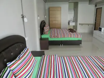 a living room with two beds and a couch at Pineapple Guesthouse in Karon Beach