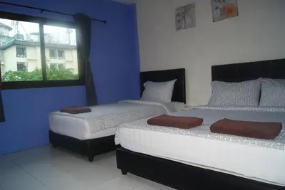 two beds in a room with a window at Pineapple Guesthouse in Karon Beach