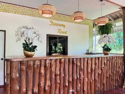 a bar with two potted plants on a wooden fence at Krabi Discovery Resort in Tha Lane Bay