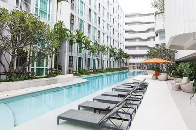 a swimming pool with chaise lounge chairs next to a building at Phuket Town 1 Bedroom Condo Luxury Facilities, The Base Downtown in Phuket Town