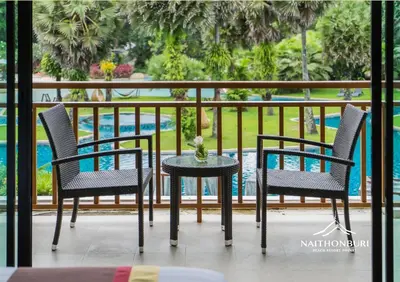 two chairs and a table on a balcony at Naithonburi Beach Resort - SHA Extra Plus in Nai Thon Beach