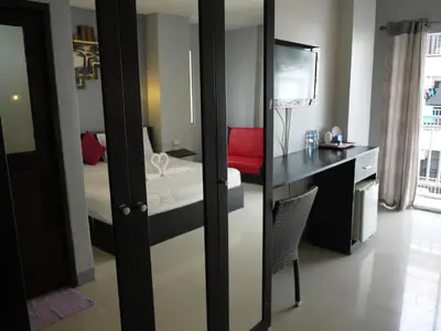 a bedroom with a bed and a desk and a mirror at Holiday Home Patong in Patong Beach