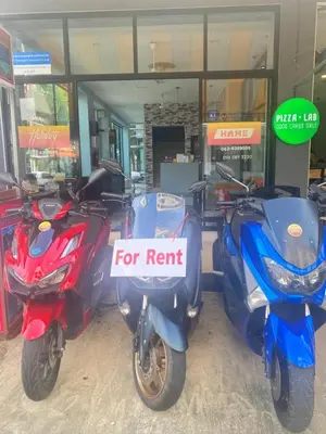 three scooters parked in front of a store with a for rent sign at Holiday Home Patong in Patong Beach