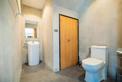 a bathroom with a toilet and a sink at The Woods Natural Park Resort Phuket in Kamala Beach