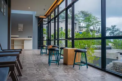 a group of stools in a room with large windows at The Woods Natural Park Resort Phuket in Kamala Beach