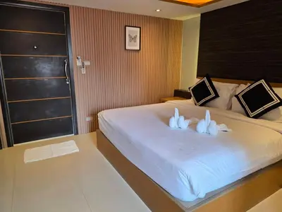 a bedroom with a large white bed with two stuffed animals on it at TT Naiyang Beach Phuket in Nai Yang Beach