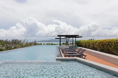 a swimming pool with lounge chairs and a gazebo at 6-Ave Surin Apartment in Surin Beach