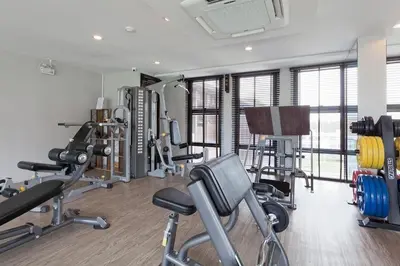 a gym with several treadmills and machines in a room at 6-Ave Surin Apartment in Surin Beach