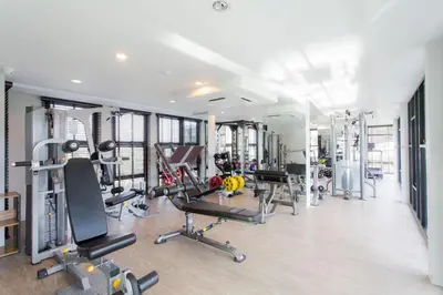 a gym with several treadmills and machines in it at 6-Ave Surin Apartment in Surin Beach