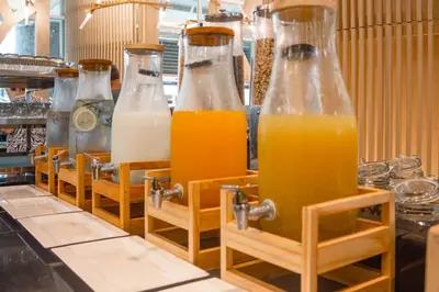 a row of bottles of orange juice on a counter at Andaman Embrace Patong, Phuket in Patong Beach