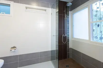 a bathroom with a shower and a window at Sandy House Rawai in Rawai Beach