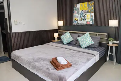 a bedroom with a large bed with two towels on it at Happy Fish Guesthouse in Patong Beach