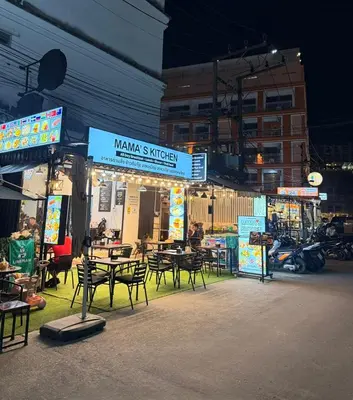 a group of tables and chairs outside of a restaurant at Happy Fish Guesthouse in Patong Beach