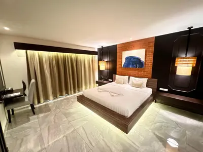 a bedroom with a bed and a desk in it at De Cozé Hotel in Patong Beach