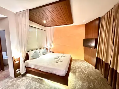 a hotel room with a bed with shoes on it at De Cozé Hotel in Patong Beach