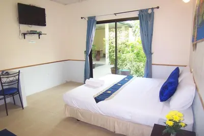 a bedroom with a bed and a tv and a window at Phuket Airport Overnight Hotel in Nai Yang Beach