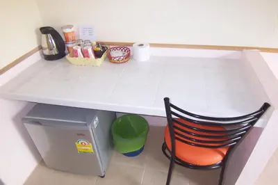 a table and a chair sitting under a counter at Phuket Airport Overnight Hotel in Nai Yang Beach