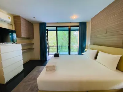 a bedroom with a large white bed and a large window at The Unity Patong in Patong Beach
