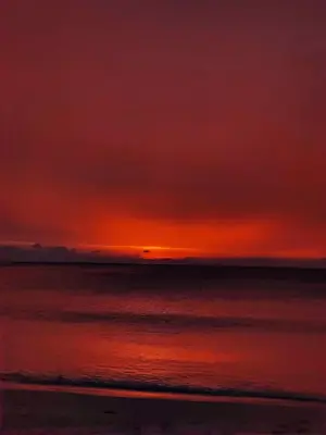 a sunset over the ocean with a beach at The Mantra Hotel Kata Noi in Kata Beach