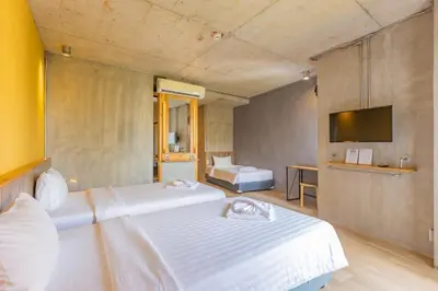 a hotel room with two beds and a television at EcoLoft Hotel - SHA Plus in Phuket Town
