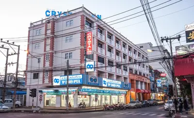a large building on a city street with cars at Crystal Inn in Phuket Town
