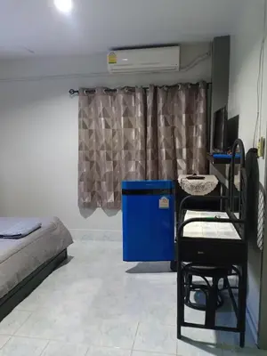 a bedroom with a bed and a blue dresser and a window at Nit Guest House in Kata Beach