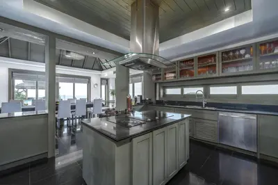 a large kitchen with a large island in the middle at Baan Phu Prana Boutique Villa in Surin Beach