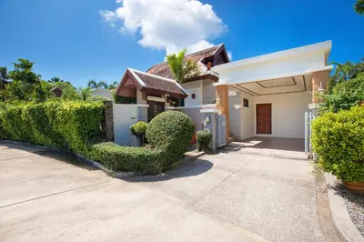 a house with a hedge in front of a driveway at Tropical Living at 3BR Pool Villa Bianca, Baan Bua Luxury Estate, Nai Harn Beach in Rawai Beach