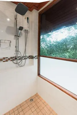 a shower in a bathroom with a window at Krabi Villa Phu Khao Private Resort in Klong Muang Beach
