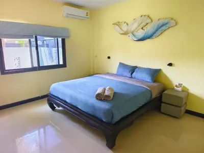 a bedroom with a bed with shoes on it at Thai family rawai Swimming pool villa Hotel in Rawai Beach