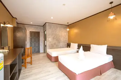 a hotel room with two beds and a desk at SB Living Place Hotel Phuket Town in Phuket Town