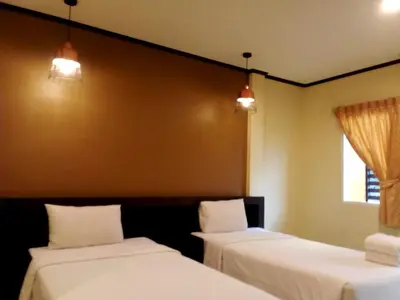 two beds in a room with two windows at SB Living Place Hotel Phuket Town in Phuket Town