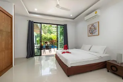 a bedroom with a large bed and a balcony at Modern 3br Boutique Pool Villa by Intira Villas in Rawai Beach