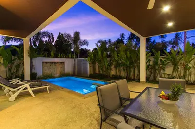 a backyard with a swimming pool and a table and chairs at West facing 3br Boutique Pool Villa by Intira Villas in Rawai Beach
