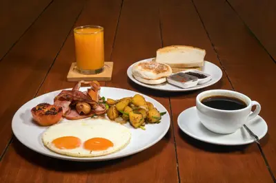 a table with two plates of breakfast food and a cup of coffee at Large 3br Boutique Villa with big Pool by Intira Villas in Rawai Beach