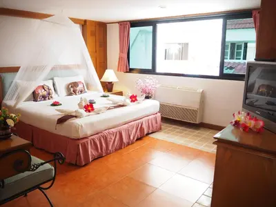 a bedroom with a bed with a mosquito net at Your Place Inn in Karon Beach