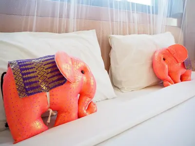 two orange stuffed elephants sitting on a bed at Your Place Inn in Karon Beach