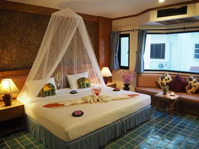 a bedroom with a bed with a canopy at Your Place Inn in Karon Beach