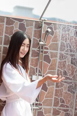 a woman is standing in front of a shower at Baan Kamala Fantasea Hotel in Kamala Beach