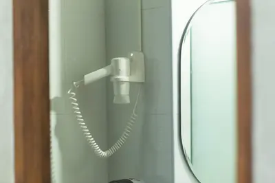a phone hanging on a wall next to a mirror at Baan Kamala Fantasea Hotel in Kamala Beach