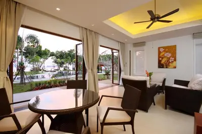 a living room with a ceiling fan and a table and chairs at Laguna Villas Boutique Hotel in Ko Yao Noi