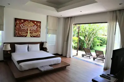 a bedroom with a large bed and a sliding glass door at Laguna Villas Boutique Hotel in Ko Yao Noi