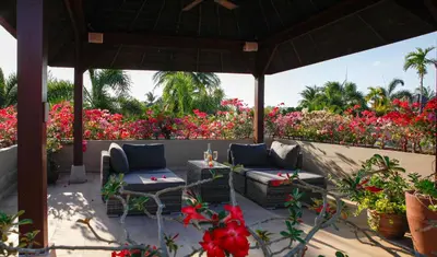 a patio with chairs and tables and flowers at The Residence Bantao Villa unit 121 in Bang Tao Beach