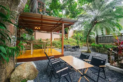 an outdoor patio with a wooden table and chairs at Thai Modern Resort & Spa 