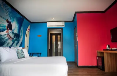 a bedroom with a white bed and a colorful wall at Must Sea Hotel - SHA Hotel in Kata Beach