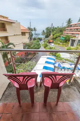 a balcony with two chairs and a view of a beach at PorterHouse Beach Hotel in Patong Beach