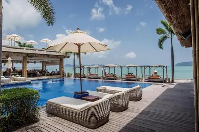 a pool at a resort with chairs and an umbrella at Dahlia 2 Bedroom Amazing Seaview in Rawai Beach
