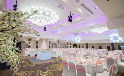 a large banquet hall with white tables and white chairs at Pearl Hotel Phuket in Phuket Town