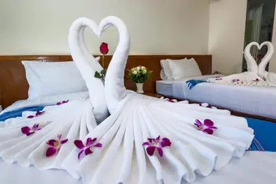 two swans in a wedding dress on a bed at Baan Vanida Garden Resort in Karon Beach