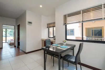 a living room with a dining room table and chairs at Amarin Hotel Patong in Patong Beach